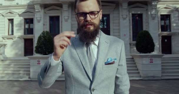 En stilig affärsman som rätar ut sina glasögon — Stockvideo