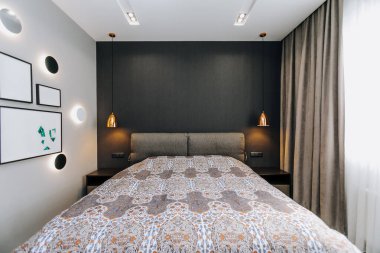 Şık ve modern bir yatak odası güzel ışıklandırma ve zarif dekorasyon unsurları barındırıyor.