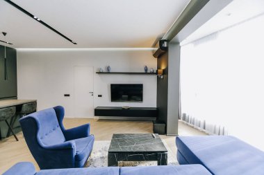 Zarif mavi sandalyeler ve çağdaş ev dekorasyonları için tasarlanmış şık bir oturma odası.