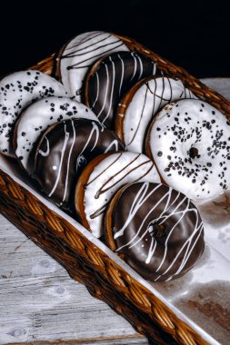 Güzel bir sepetin içine yerleştirilmiş çekici ve lezzetli bir çikolata ve vanilyalı çörek çeşidi.