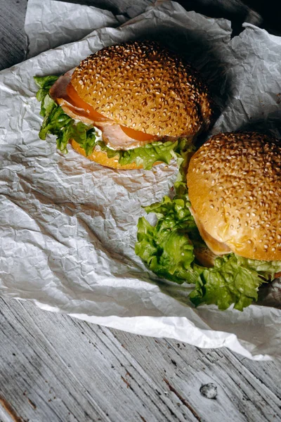 Bu lezzetli susamlı burgerlerin tadını çıkarın. Üstünde taze, taze marul var. Her durum için ideal bir yemek.