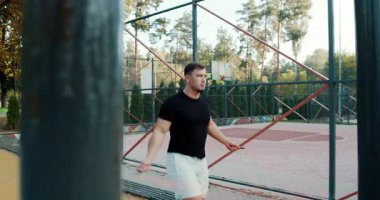 A fitness enthusiast shows impressive agility and skill while jumping rope in a bright, sunny outdoor gym