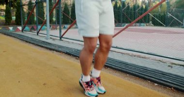 A guy energetically jumping rope outdoors, proudly showcasing his fitness level and commitment to athleticism