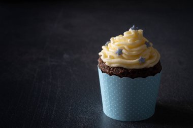 Copy Space ile Koyu Arka Plan Üzerinde Yıldız Sprinkles ile Bebek Mavi Cupcake
