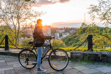 Kyiv (Kiev), Ukrayna - Haziran 01, 2020: Ukrayna Ulusal Müzesi yakınlarındaki ünlü bir izleme yerinden gün batımını seyreden genç bir kadın