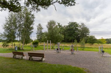 Modern bir spor kompleksi, birçok ağacın olduğu bir arazinin yakınında.