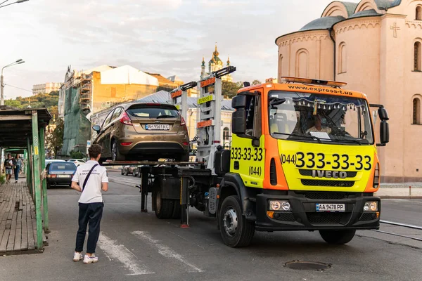Kyiv (Kiev), Ukrayna - 30 Temmuz 2020: Bir arıza kamyonu, çekici, hurda, hurda, kurtarma aracı park ihlali nedeniyle bir arabayı boşaltıyor ve bir müfettiş ceza kesiyor