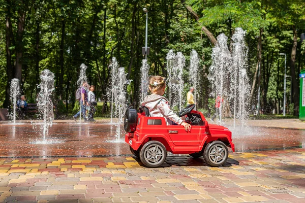 キエフ キエフ ウクライナ 2020年7月31日 小さなかわいい女の子は公園で小さな赤い車を運転し 噴水を見て 楽しい時間を楽しんでいます — ストック写真