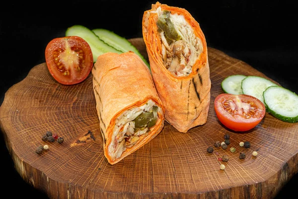 Shawarma ikiye bölünmüş, tahta arka planda.
