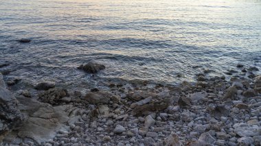 Kayalık deniz kıyısı ve alacakaranlıkta dalgalar