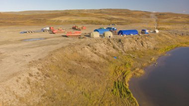 Tundranın ortasında çadır ve sondaj kulesiyle jeolojik bir kamp. tundra