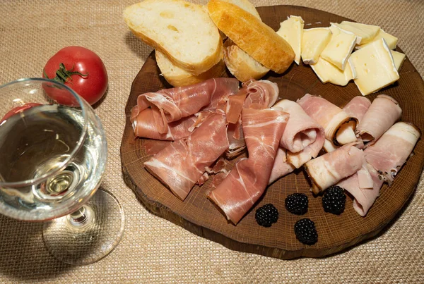Wine appetizer. Ham, Parma ham, baguette, Cheese on a wooden stand. — Stock Photo, Image