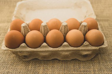 Karton bir kabın içinde on tavuk yumurtası. Konsept, seçici odaklanma. Kırsal biçim