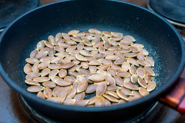 Kızartma tavasında kabak çekirdeği ve elektrikli soba..