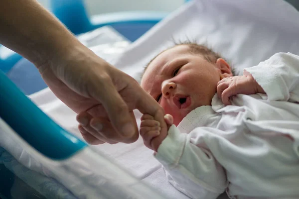 Doğum öncesi hastanede beşiğinde yatan yeni doğmuş güzel bir erkek bebek.