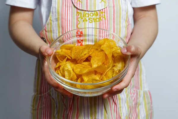 Aranyos kislány kezében tányér fűszeres chips — Stock Fotó