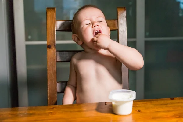 Adorável menino comendo queijo cottage de colher, lanche de leite saudável . — Fotografia de Stock