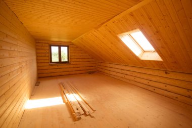 Kereste tavanı ve tavan penceresi olan boş bir oda.