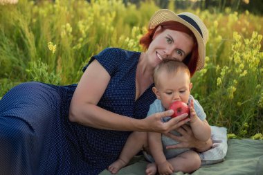 Anne ve oğlu yaz tarlasında. Anne oğluyla oynuyor..