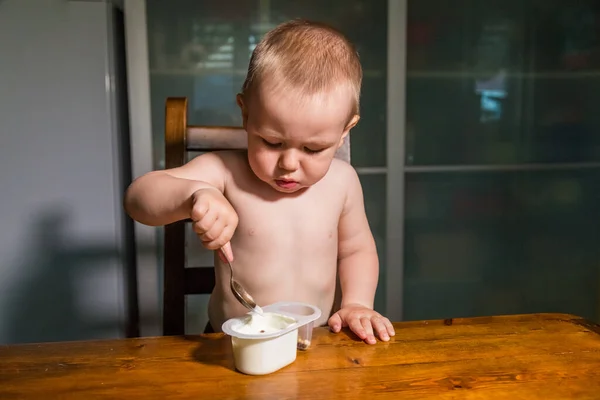 Bambino adorabile che mangia fiocchi di latte da cucchiaio, spuntino di latte sano . — Foto Stock