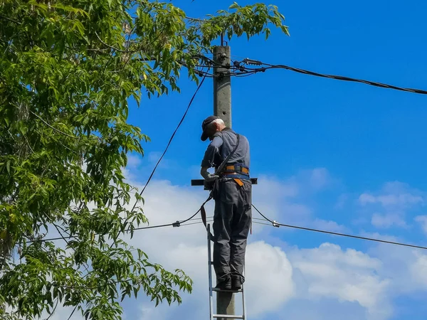 Elektricien repareert, elektriciens repareren draad op elektrische elektriciteitspaal — Stockfoto