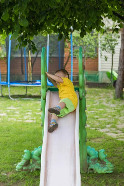 Um menino está rolando para baixo no pátio — Fotografia de Stock
