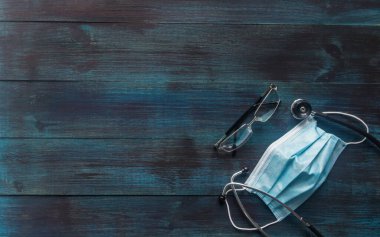 Ahşap zemin üzerinde stetoskop ve ofis nesneleri.