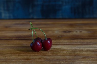 Masada taze kiraz, ahşap mavi arka planda..