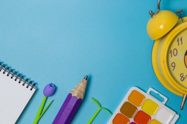 Okul malzemeleri. Kopyalama alanı olan mavi arkaplan üzerindeki üst görünüm.