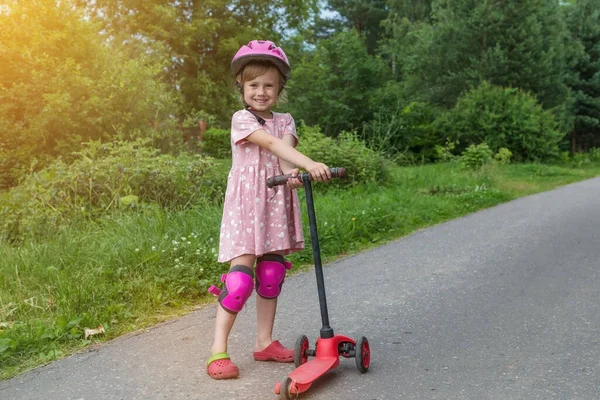Köy yolunda scooter süren aktif küçük bir kızın portresi. — Stok fotoğraf