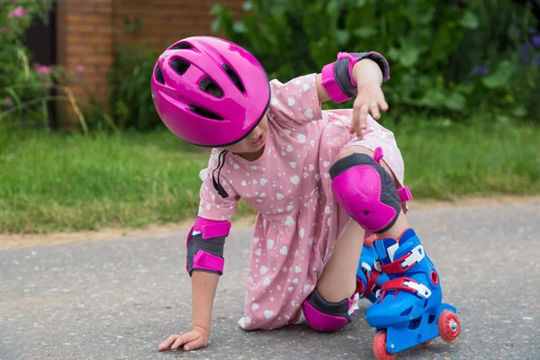 Küçük bir kız kaykay yaparken asfalta düştü. — Stok fotoğraf