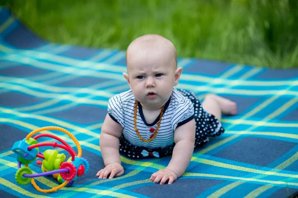 Portré egy 6 hónapos kisbabáról a pázsiton egy vicces bögrével. — Stock Fotó