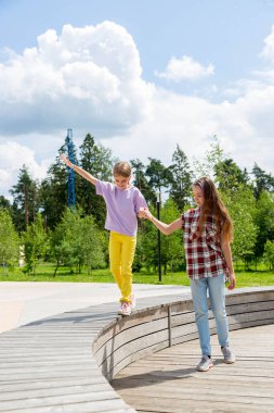 Yaşlı ve güzel bir kız, yaz zamanı şehir parkında küçük tatlı bir kızla el ele gider..