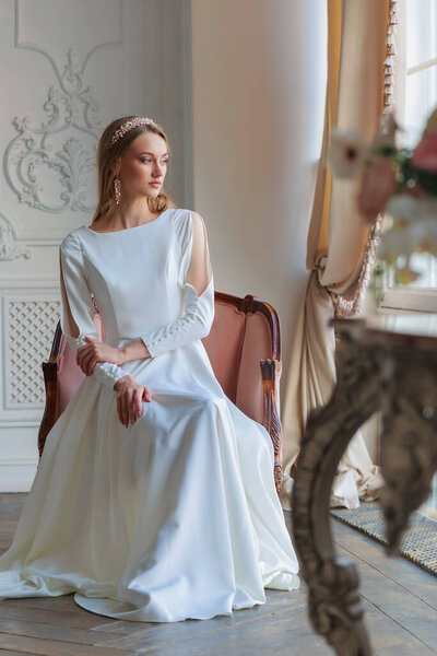 Невеста с прической и макияж в роскошном свадебном платье подготовки к свадьбе. Портрет красивой девушки с светлыми волосами и голубыми глазами в студии