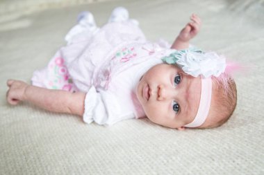 Bir aylık yatağında kameraya bakarak uzanan beyaz beyaz beyaz erkek bebek portresi..