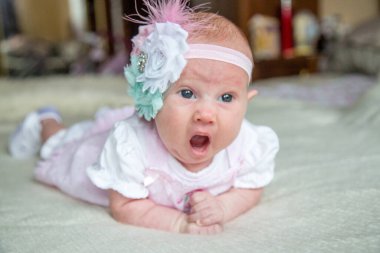 Bir aylık yatağında kameraya bakarak uzanan beyaz beyaz beyaz erkek bebek portresi..