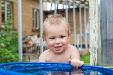 Bir çocuk ellerini su varilinde yıkıyor..