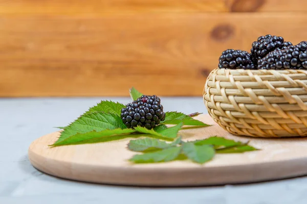 Ripe Blackberry Leaves Wooden Cutting Board Wicker Bowl Concrete Background — Stock Photo, Image