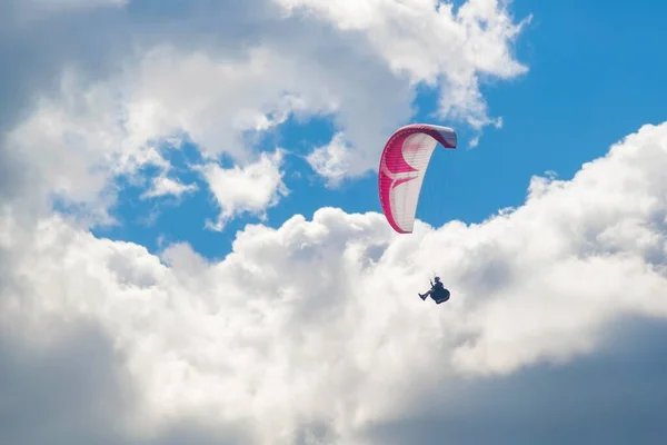 有一个滑翔伞在蓝天的云彩背景下飞翔 在阳光灿烂的日子里 滑翔在天空中 — 图库照片