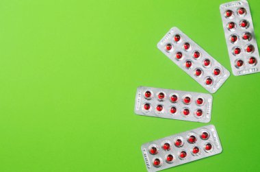 Şeffaf gümüş konteynırda canlı renk tedavisi. Kırmızı ilaç kapsüllü metal kabarcık. Sağlık sigortası ilaç eczanesi geçmişi..