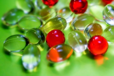 Açık sarı ve kırmızı renkli ilaç kapsülleri. Sağlık sigortası ilaç eczanesi geçmişi.