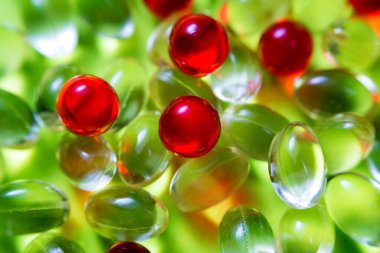 Açık sarı ve kırmızı renkli ilaç kapsülleri. Sağlık ilaçları eczanesinin arka planı. E vitamini ve Omega 3 vitamin malzemeleri. Soyut tıbbi geçmiş.