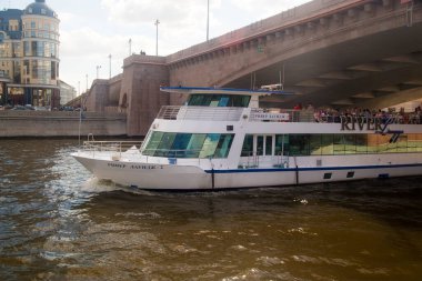 MOSCOW, RUSSIA - 21 AĞUSTOS 2020: Nehir motorlu gemisi Moskva nehri üzerindeki köprünün altından yola çıkıyor. Güneş ışınları fotoğrafta sanatsal gölgeler yaratır..