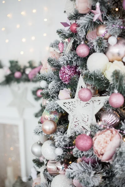 Pembe oyuncaklarla yeşil ve beyaz Noel ağacı Yeni yıl hediyeleri.