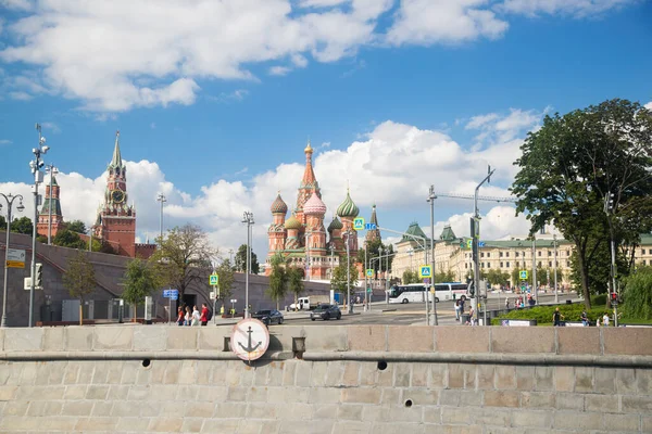 MOSCOW, RUSSIA - 21 AĞUSTOS 2020: Spasskaya Kulesi ve Katedral of Vasily the Holy Saint Basil 's Katedrali Kızıl Meydan' da ve Rcarriageway 'in güneşli yaz gününde Moscva-nehrinin setinde