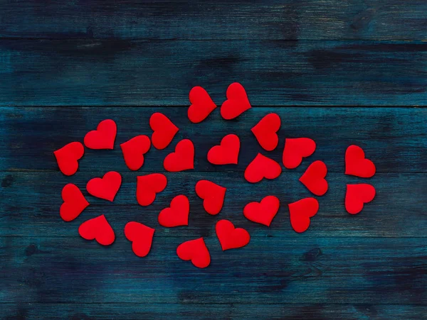 ロマンチックなバレンタインデーの背景濃い青の木製の背景に赤いサテンの心 — ストック写真