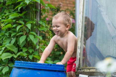 Bir çocuk ellerini su varilinde yıkıyor..