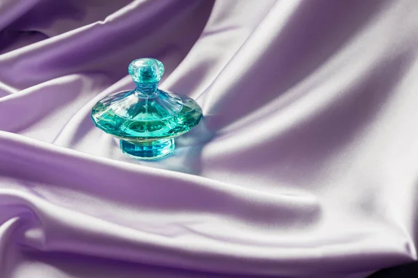 Butelka Perfum Jedwabiu Liliowym Składane Tło Tkaniny Luksusowy Zapach Kosmetyczny — Zdjęcie stockowe