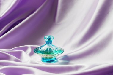 Leylak ipeği katlanmış kumaş kaplamalı parfüm şişesi. Lüks Koku Koku Kozmetik Güzellik Ürünü.