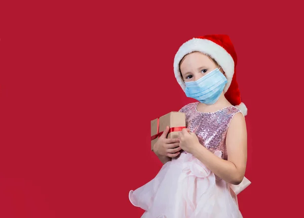 Αξιολάτρευτο Cacusian Κοριτσάκι Φορώντας Ιατρική Μάσκα Καπέλο Santa Κουτί Δώρου — Φωτογραφία Αρχείου